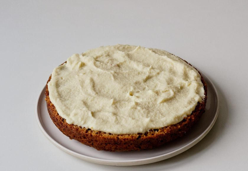 1. Этап. Морковный торт без яиц: Смажьте половину бисквита кремом.