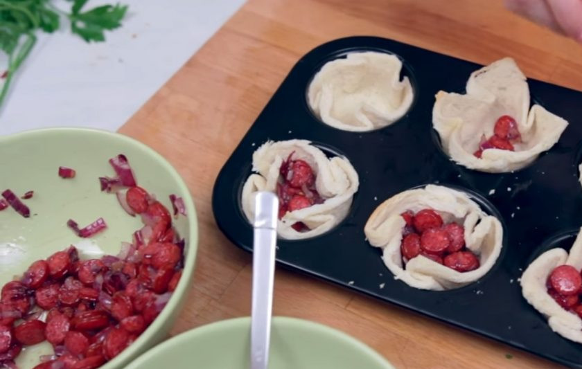 1. Этап. Тостовые корзинки с начинкой: 3. В отдельной миске яйцо взбейте с молоком и солью, добавьте мелко нарезанную зелень. В готовые корзинки выложите сначала колбаски с луком, затем — тертый сыр и яичную смесь.