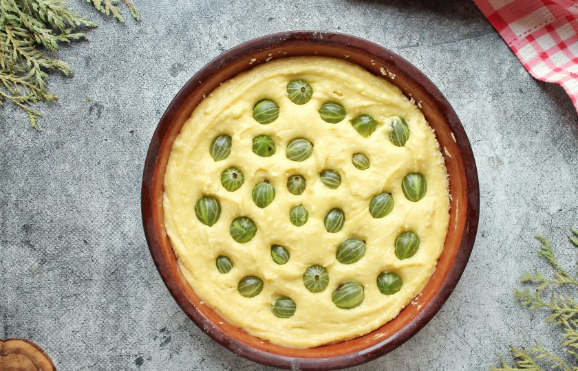 1. Этап. Пирог с крыжовником и творогом: Форму для выпечки смажьте растительным маслом. Перелейте в форму тесто и утопите в нем подготовленный крыжовник.