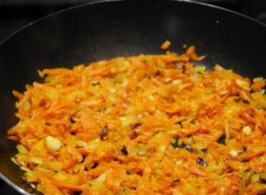 1. Этап. Салат с курицей и черносливом слоеный: Обжариваем лук с морковью на растительном масле до мягкости моркови.