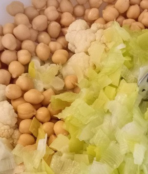 1. Этап. Салат из цветной капусты и нута: Тем временем ошпарить лук-порей кипятком, поддержать в кипятке 2 минуты. Затем процедить и отправить лук-порей в салатницу к нуту и цветной капусте. Перемешать.