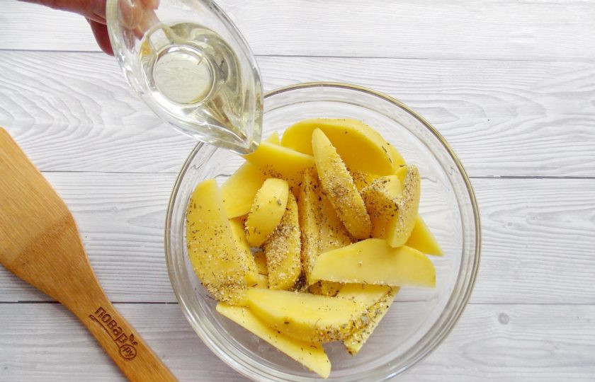 1. Этап. Картофельные дольки с чесноком: Посыпьте специями картофельные дольки. Налейте подсолнечное масло. Хорошо перемешайте картофель с маслом и специями.