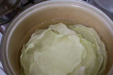 1. Этап. Сосиски в капустных листьях: Бланшируем капустные листья в слегка подсоленной кипящей воде минут 10. Затем срезаем утолщения. Если листья толстоватые, после бланшировки можно прокатать их скалкой.