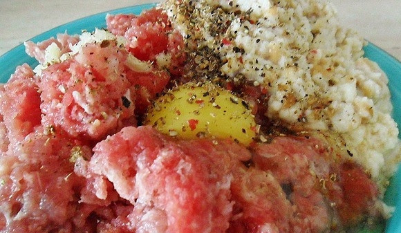 1. Этап. Биточки, запеченные под сметанным соусом: Первым делом вам необходимо приготовить фарш. Для этого поломайте хлеб на кусочки и замочите в ста пятидесяти миллилитрах молока. Затем отожмите и положите в миску. Туда же положите мясной фарш, вбейте куриное яйцо, добавьте соль и любимые специи по вкусу. Все тщательно перемешайте.