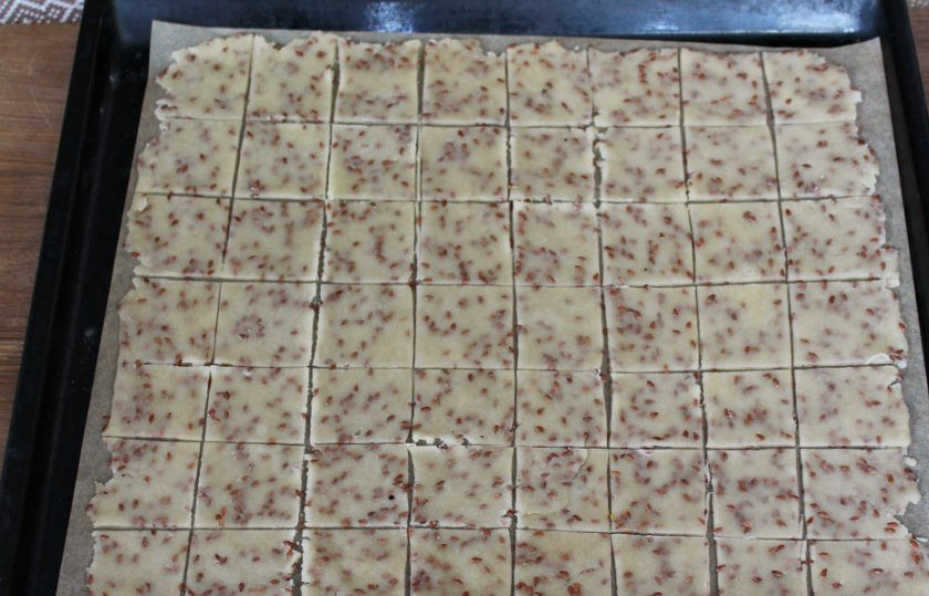 1. Этап. Постное галетное печенье: Нарезаем тесто на квадраты. Пергамент с тестом перекладываем на противень для запекания и отправляем в разогретую духовку на 8-10 минут. Готовим при температуре 180 градусов.