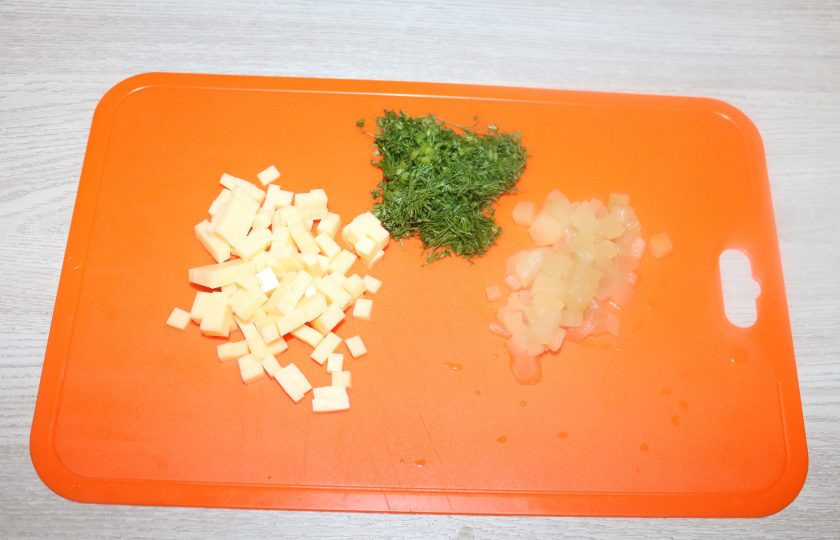 1. Этап. Мясной рулет с ананасами: Сыр и ананасы нарежьте кубиками, зелень мелко нарубите.