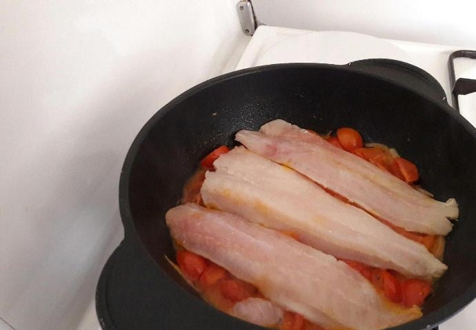 1. Этап. Мерлуза с овощами: Позже сверху выложите рыбу. Тушите блюдо под крышкой на слабом огне 3 минуты.