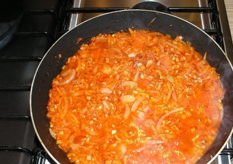 1. Этап. Суп из говядины с томатной пастой: Морковку чистим, моем, натираем на крупной терке. Добавляем в сковороду с луком, чесноком и томатной пастой. Солим. Обжариваем смесь около пяти минут на тихом огне.