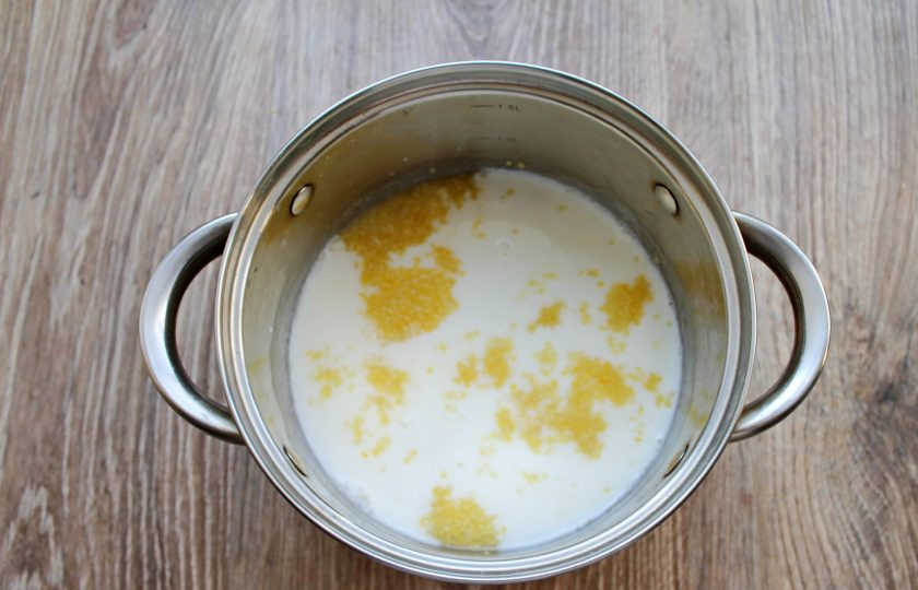 1. Этап. Кукурузная каша с черносливом: Влейте в кастрюлю с кашей молоко, перемешайте.