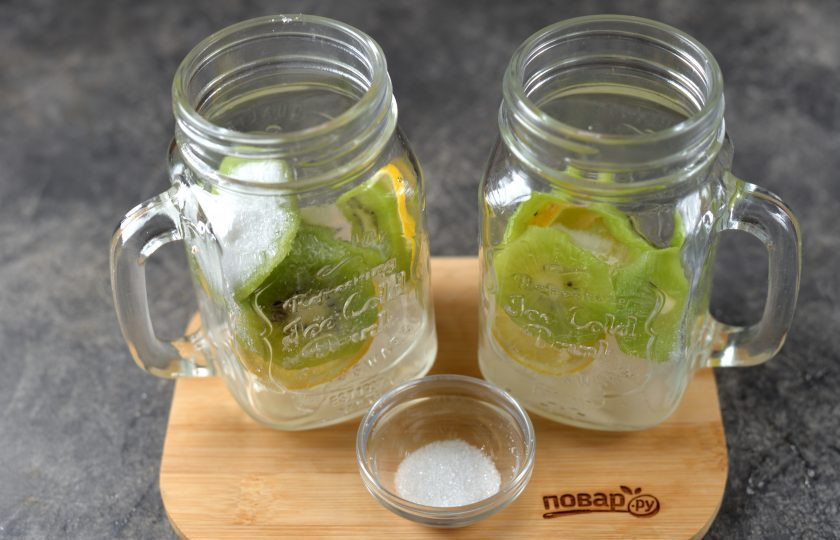 1. Этап. Лимонад «Киви»: Киви почистите от кожуры, нарежьте такими же тонкими кружочками, разложите в стаканы, всыпьте по вкусу сахар. Сахар можно предварительно развести в минимальном количестве воды до состояния сиропа и его разлить по стаканам.