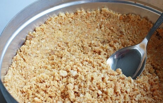 1. Этап. Новогодний чизкейк с клюквой: 2. Выложите полученную крошку в жаропрочную форму со съемными бортиками.