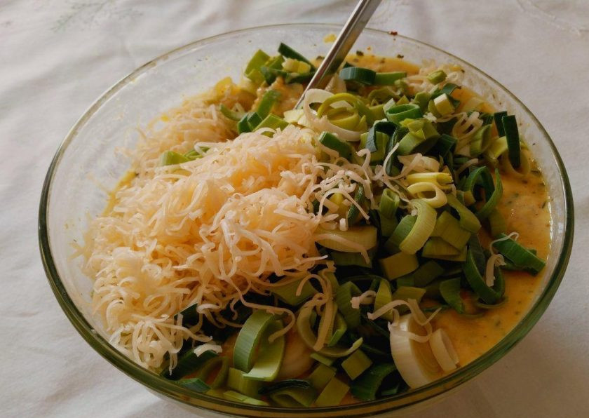 1. Этап. Кукурузно-сырная запеканка: Постепенно введите в кукурузную крупу яичную смесь, смешивая компоненты ложкой, всыпьте измельчённый лук и половину натёртого сыра, перемешайте до однородной консистенции.