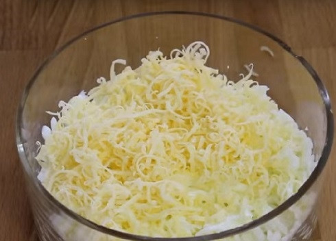 1. Этап. Салат из тунца и яиц: Второй слой — натертый на терке сыр.