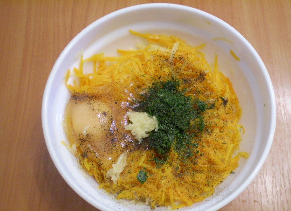 1. Этап. Драники из тыквы: Добавьте сырое яйцо, специи, соль, зелень. Все перемешайте.