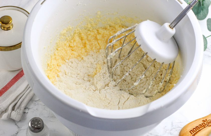 1. Этап. Рогалики песочные с орехами: Всыпьте муку по частям и вмешайте ее в массу.