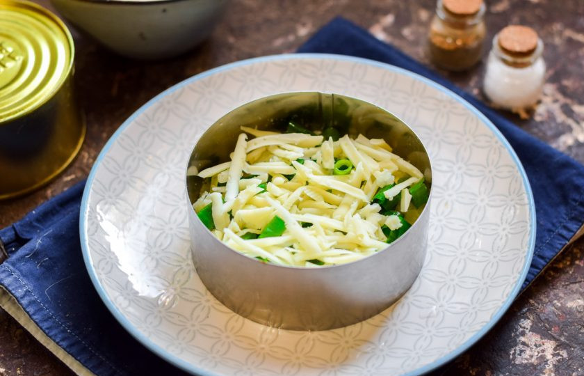 1. Этап. Мимоза с консервой: Твердый сыр натрите средней стружкой и посыпьте салат.