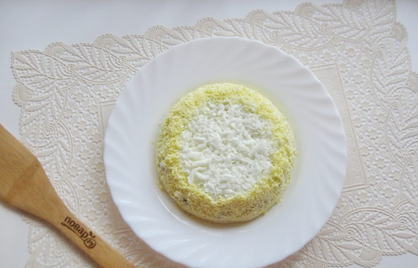 1. Этап. Салат с консервированной горбушей и грибами: Желтки разомните и выложите на бока салата.