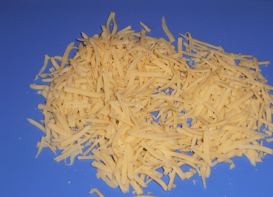 1. Этап. Тарталетки с ананасом и курицей: 4. На средней терке натереть сыр. При желании можно использовать мягкий сливочный сыр.