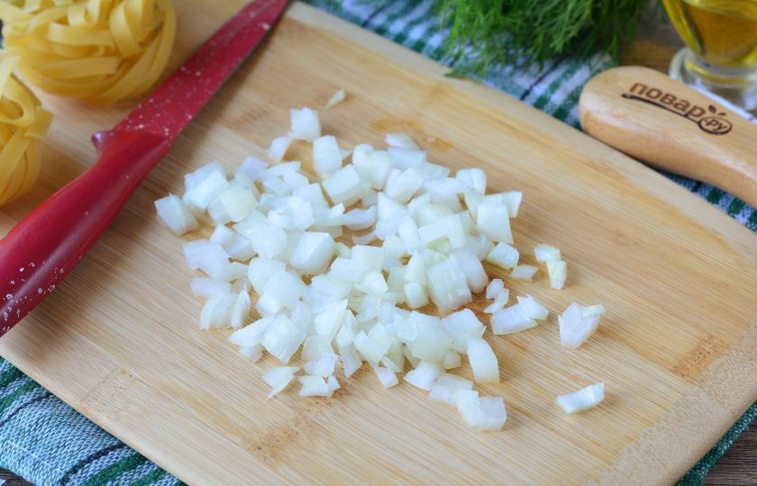 1. Этап. Фетучини с кабачками: Пока варятся макаронные изделия, почистите и нарежьте кубиками лук.