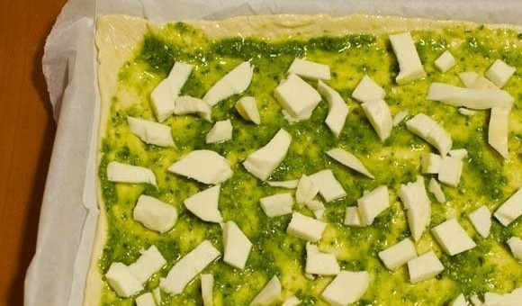 1. Этап. Пицца с песто и томатами: 1. Противень устелите пергаментом и выложите тесто для пиццы, раскатанное в пласт. Сформируйте невысокие бортики, смажьте тесто небольшим количеством оливкового масла и соусом песто, посолите. Выложите измельченную моцареллу.