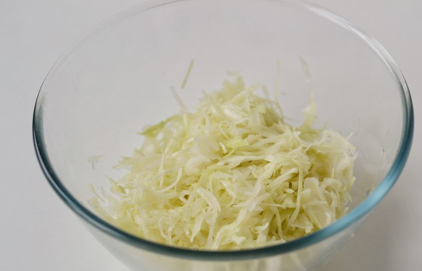 1. Этап. Салат с капустой и нутом: Капусту тонко нашинкуйте. Посолите и помните руками, чтобы она стала мягче.