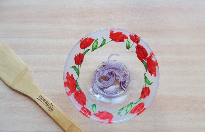 1. Этап. Салат с фасолью и яблоками: Красный лук очистите, помойте и нарежьте перьями или полукольцами. Выложите в салатник.