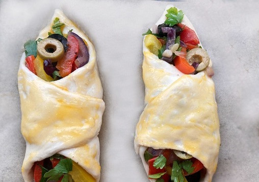 1. Этап. Слоёные башмачки с индейкой и овощами: Тесто (2 пласта) раскатайте и разрежьте каждый пласт на 6 одинаковых квадратиков. В центр каждого квадрата по диагонали положите 1 кусочек грудки индейки. Сверху положите обжаренные овощи и рубленную зелень петрушки. Соедините два противоположных края каждого квадрата. Получаются вот такие конвертики-башмачки. Тесто смажьте взбитым яйцом. Уложите получившиеся башмачки на противень, застеланый пергаментной бумагой. Выпекайте в разогретой до 180 духовке 35-40 мин.