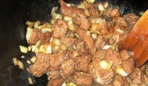 1. Этап. Говядина, тушенная в кисло-сладком соусе: В сковороде растопите кусочек сливочного масла. На сильном огне поджарьте говядину, чтобы она покрылась снаружи румяной корочкой, а внутри осталась сочной. Затем к мясу добавьте нарезанный кусочками или полукольцами белый репчатый лук.