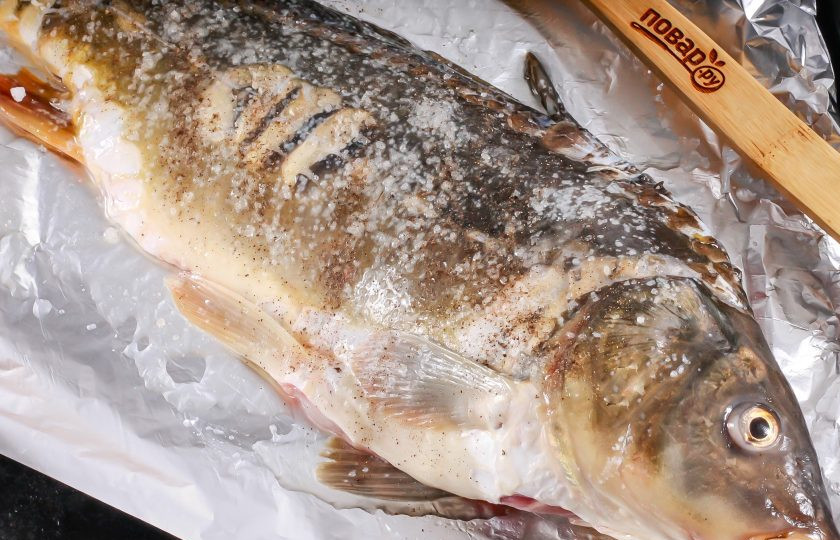 1. Этап. Карп в горчице в духовке: Застелите противень фольгой и смажьте растительным маслом. Карпа натрите солью и лимонным соком внутри и снаружи. Если у вас есть свободное время, то сделайте это заранее за 1-2 часа. Лимонный сок удалит аромат тины из рыбной мякоти. Выложите карпа на фольгу, стараясь убрать хвост и голову, чтобы они не попали на сам противень, иначе пристанут к нему в процессе запекания.