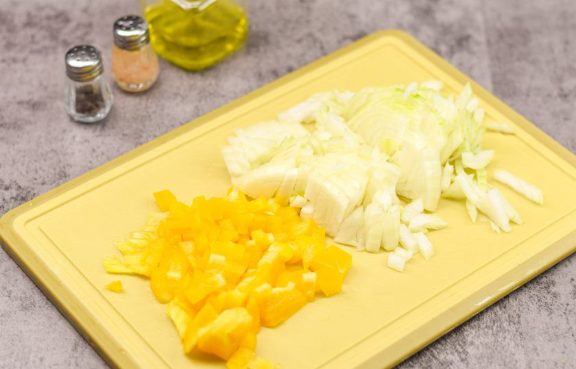 1. Этап. Гречка с соусом Болоньезе: Лук очистите и нарежьте кубиками. Перец также нарежьте небольшими кубиками.