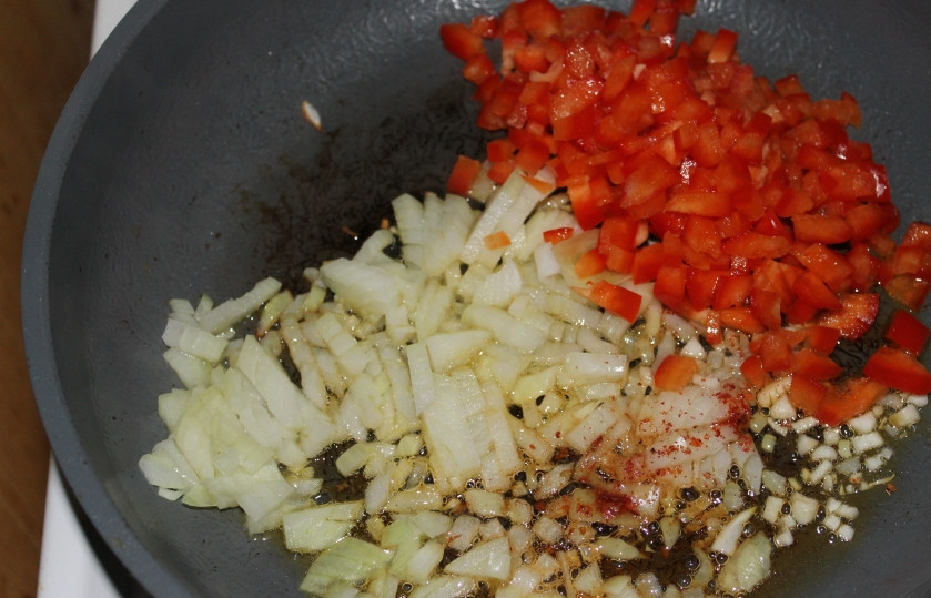 1. Этап. Паэлья маринара: Чеснок обжарить на оливковом масле и выбросить. А на ароматном масле обжарить до прозрачности мелко порезанный репчатый лук, болгарский перец, перец чили.