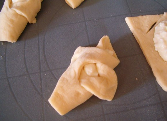 1. Этап. Плюшки с творогом: Второй край обматываем, как на фото. Теперь выкладываем плюшки на противень, смазанный маслом, сверху плюшки смазываем желтком, чуть посыпаем сахаром, даём разстояться 15 минут и ставим в духовку 180 градусов примерно на 20 минут. Плюшки с творогом готовы!