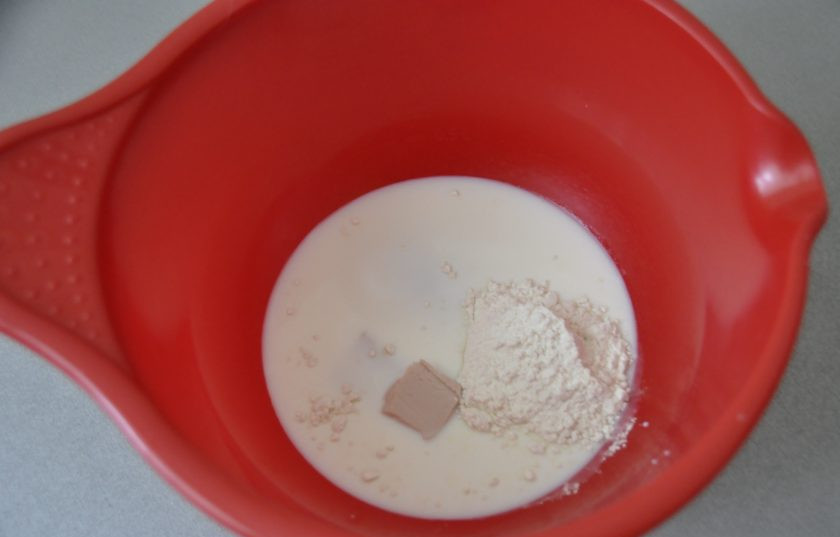 1. Этап. Пропитка для кулича: Сначала займитесь приготовлением куличей, для этого подогрейте молоко (около 36 градусов), добавьте свежие прессованные дрожжи, по 1 столовой ложке муки и сахара от их общего количества.