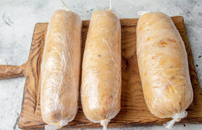 1. Этап. Колбаса куриная домашняя быстрого приготовления: Разделите фарш на 3-4 части, в зависимости от желаемой толщины готового продукта. Я разделила на 3 части. Каждую часть выложите на пищевую пленку, плотно заверните, завязав края.