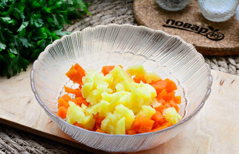 1. Этап. Салат Осенняя палитра: Заранее отварите картофель и морковь до мягкости. Варите их примерно 25 минут, затем остудите и почистите. Нарежьте кубиками и выложите в салатник.
