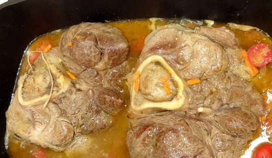 1. Этап. Тушеная голяшка: Нарежьте томаты, измельчите один зубчик чеснока. Отправьте их вместе с морковью и луком к голяшке. Посолите и поперчите. Закройте крышкой. Тушите на маленьком огне около двух часов. Каждые 20 минут необходимо переворачивать мясо. Можете добавить немного воды в сковороду.