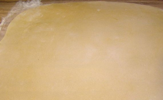 1. Этап. Тесто на лазанью: Присыпьте стол мукой. Тесто разделите на несколько частей. Каждую раскатайте в тонкий пласт 1-2 мм толщиной.