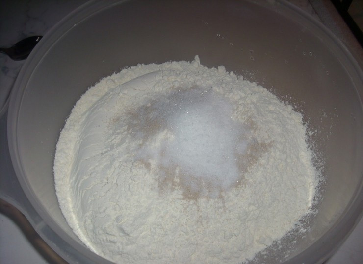 1. Этап. Пончики в сахаре: 1. Просейте в миску муку, добавьте сухие дрожжи, 2 чайные ложки сахара, соль и перемешайте.