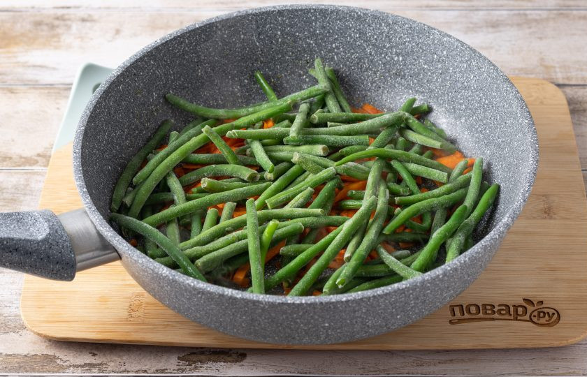 1. Этап. Замороженная стручковая фасоль на сковороде: Добавьте замороженную стручковую фасоль. Готовьте еще 3-5 минут, чтобы она разморозилась и приобрела чуть золотистый цвет.