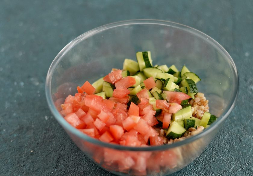 1. Этап. Салат с полбой: Переложите в большую миску полбу, добавьте нарезанные кубиками помидор и огурец.