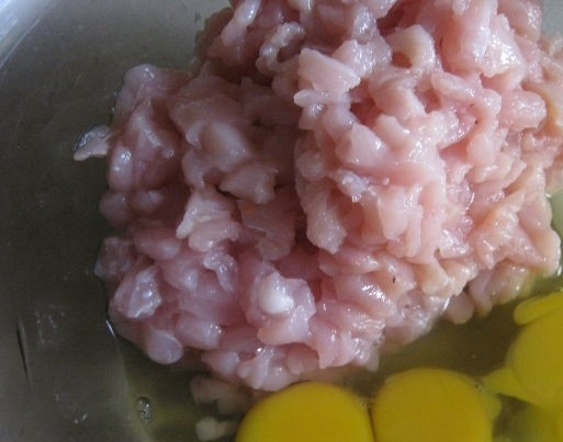 1. Этап. Сочные куриные котлеты из грудки: 4. К рубленой куриной мякоти добавьте яйца.