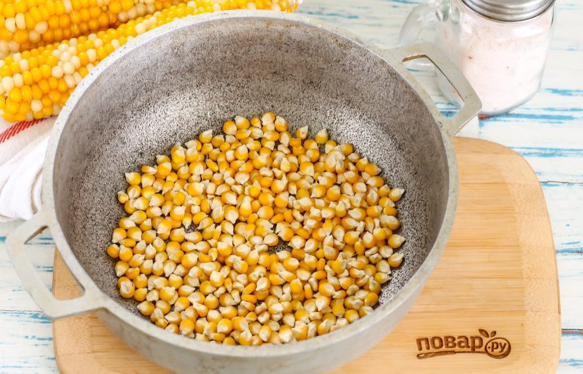 1. Этап. Попкорн из кукурузы: Влейте в казан растительное масло и прогрейте его на плите практически до кипения. Всыпьте в масло зерна кукурузы, убавьте нагрев до среднего и моментально накройте емкость крышкой. Крышку не снимайте, так как зерна при раскрывании будут разлетаться в разные стороны! Дождитесь того момента, когда треск практически закончится и выключите нагрев.