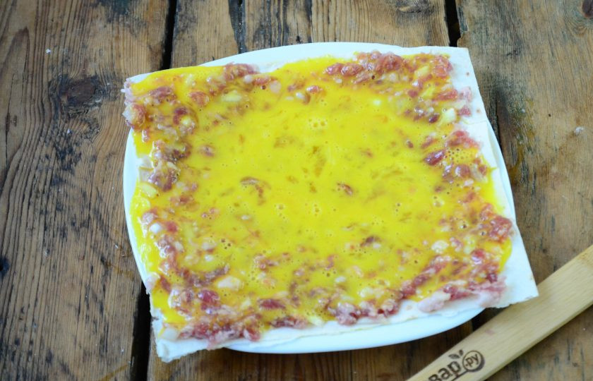 1. Этап. Бризоль в лаваше: 2 яйца взбейте с солью и перцем по вкусу. Половину массы вылейте в плоскую тарелку, положите лист лаваша, сверху вылейте остальную яичную массу и лопаткой распределите.