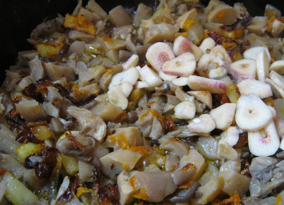 1. Stage. Fried mushrooms with rice and greens: Mushrooms (I took oyster mushrooms) boiled in salted water, cut into cubes and add to the fried onions and carrots. Stir, add spices (I took a ready-made set of hops and suneli) cloves chop garlic (you can squeeze through a press). At this stage we add hot paprika, cut it into pieces and add to the dish. Stir and stew everything for about 5 minutes.