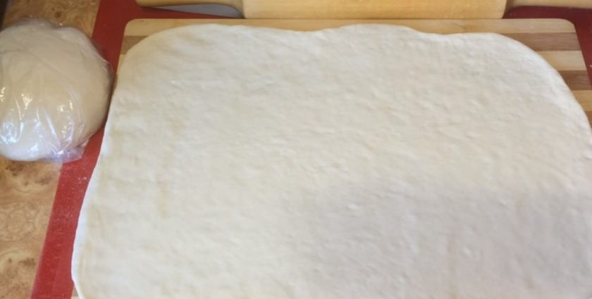 1. Этап. Паровые булочки (штрули): 5. Другую часть теста разомните в лепешку и раскатайте в большой прямоугольный пласт. Смажьте пласт растительным маслом и подровняйте края теста. Разделите тесто на полоски шириной 4 см.