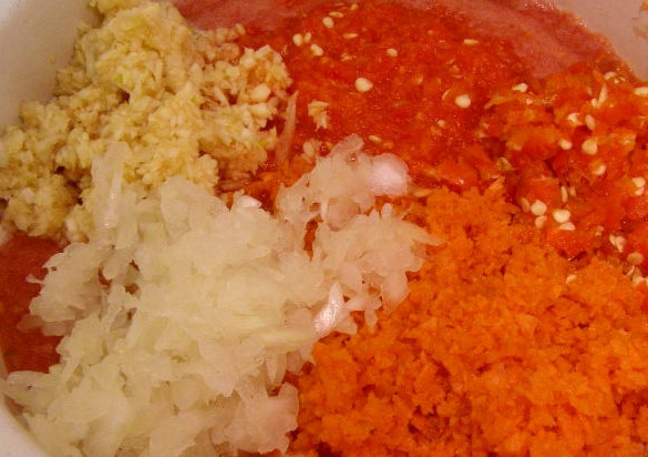 1. Этап. Аджика вареная на зиму из помидоров: Чистим морковь, чеснок и лук. Их можно потереть на терке, либо тоже перемолоть в мясорубке или комбайне. Кладем все перемолотые овощи в одну большую кастрюлю, ставим на плиту.