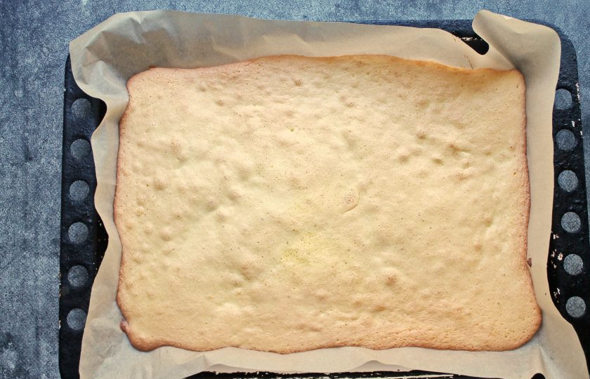 1. Этап. Рулет с крыжовником: Противень застелите пергаментом, перелейте тесто и разровняйте в пласт. Поставьте противень в горячую духовку и выпекайте при температуре 180 градусов в течение 10 минут, до золотистого цвета.