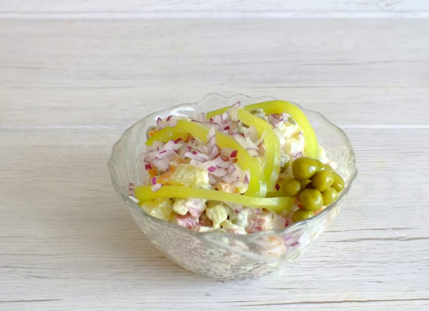 1. Этап. Салат Буковина: Фиолетовый лук нарежьте очень мелким кубиком. Болгарский перец полосами. Посыпьте сверху салат измельченным луком и выложите сверху полоски из болгарского перца. Оформите зеленым горошком.