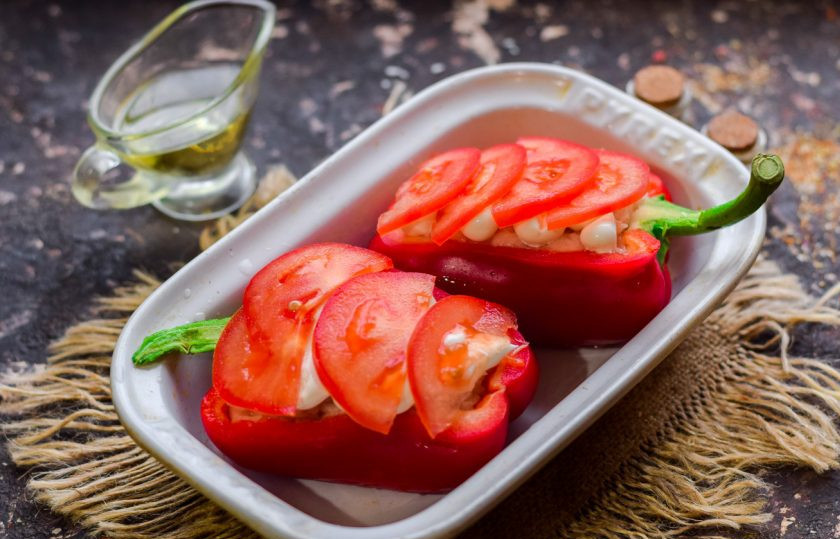 1. Этап. Перцы фаршированные куриной грудкой в духовке: Помидор нарежьте пластинами, выложите поверх перцев.