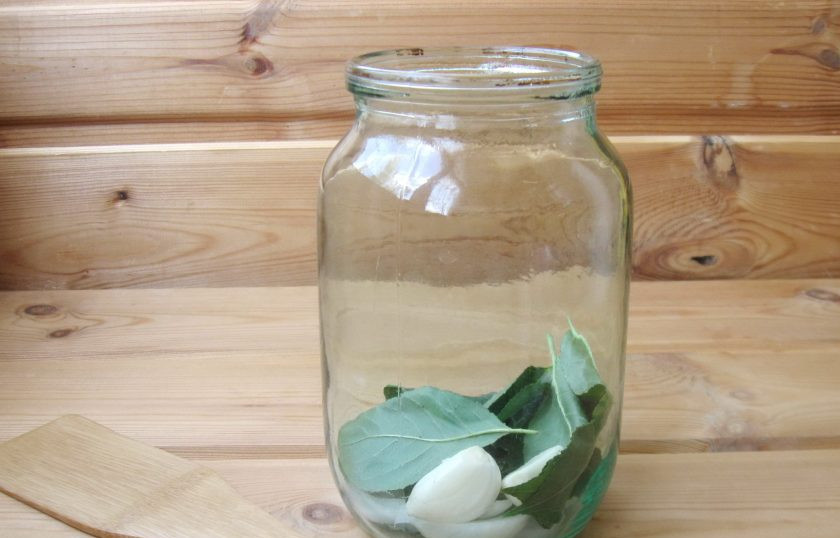 1. Этап. Помидоры на зиму с уксусом: В каждую банку добавьте очищенный чеснок.